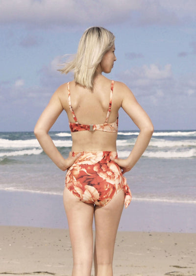 Ribbed red floral pattern bikini bottoms made from recycled sustainable material. The full coverage bikini bottoms have a tie up waist and can be high waisted or worn lower down