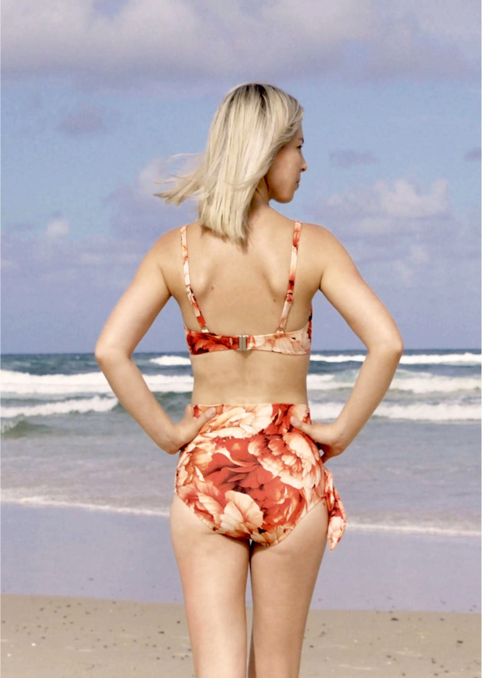 A ribbed red floral pattern underwire bikini top. The top is a balconette style and is made from recycled sustainable material