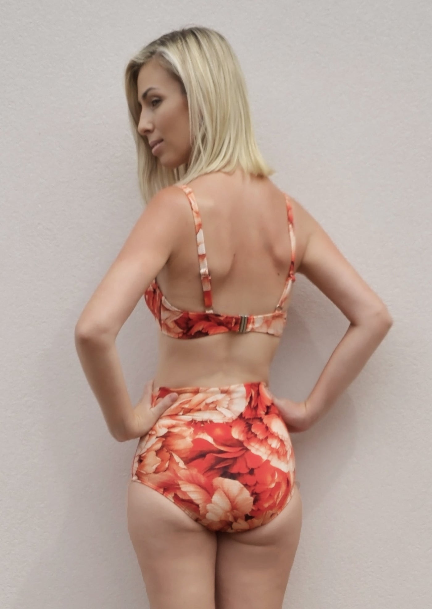 Ribbed red floral pattern bikini bottoms made from recycled sustainable material. The full coverage bikini bottoms have a tie up waist and can be high waisted or worn lower down