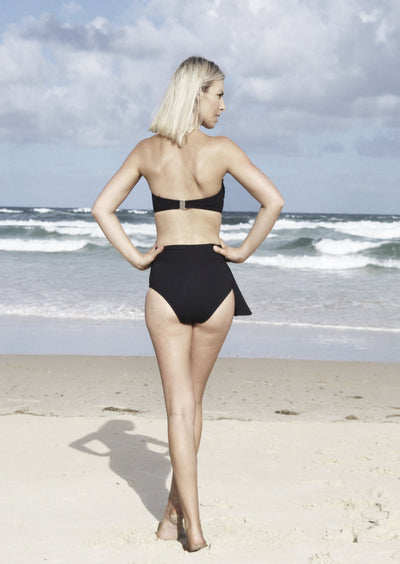 A Black rib bandeau style bikini top with ring in centre. Made from sustainable, recycled material