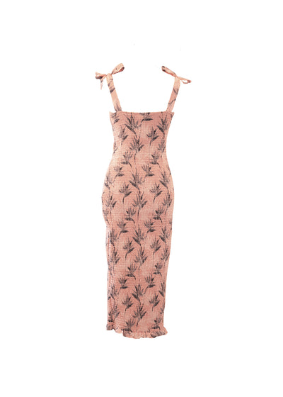 A shirred bodycon dress with tie up straps. A midi length dress with a light pink pattern.