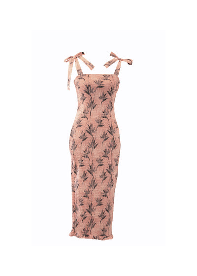 A shirred bodycon dress with tie up straps. A midi length dress with a light pink pattern.